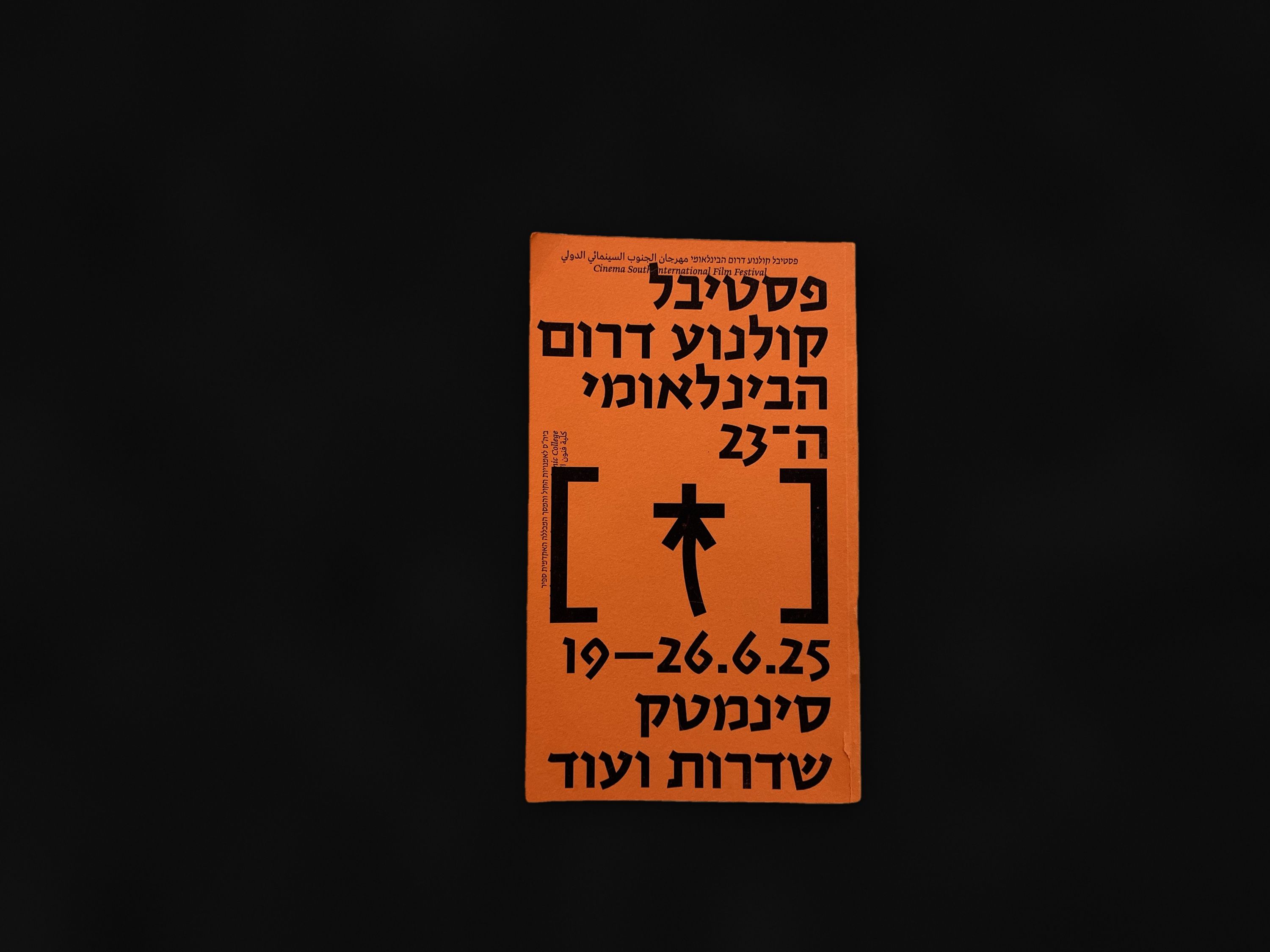 The orange program cover with the festival symbol in brackets