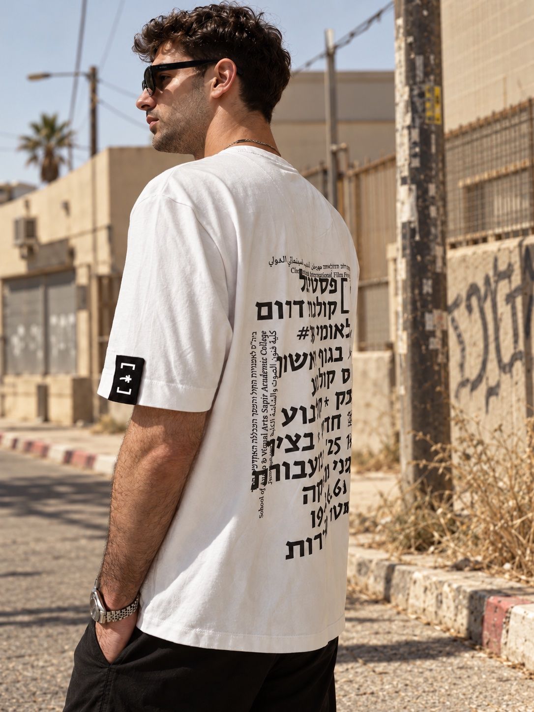 The back of a white festival T-shirt printed with the festival text