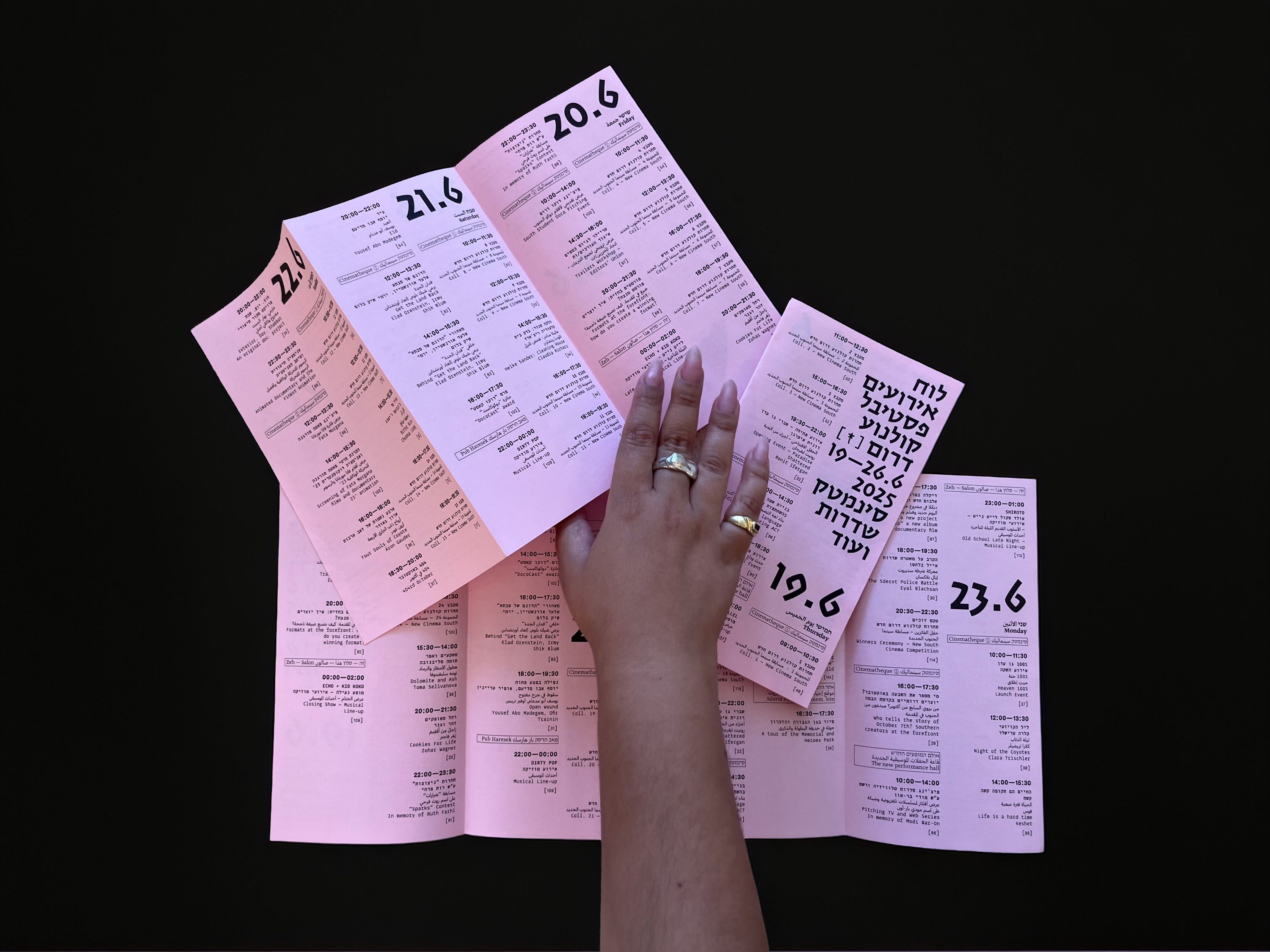 The pink festival schedule unfolded, showing the daily listings