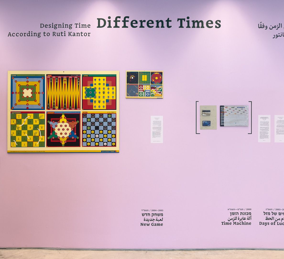 The title wall: “Different Times — Designing Time According to Ruti Kantor” above framed game-board calendars and their labels