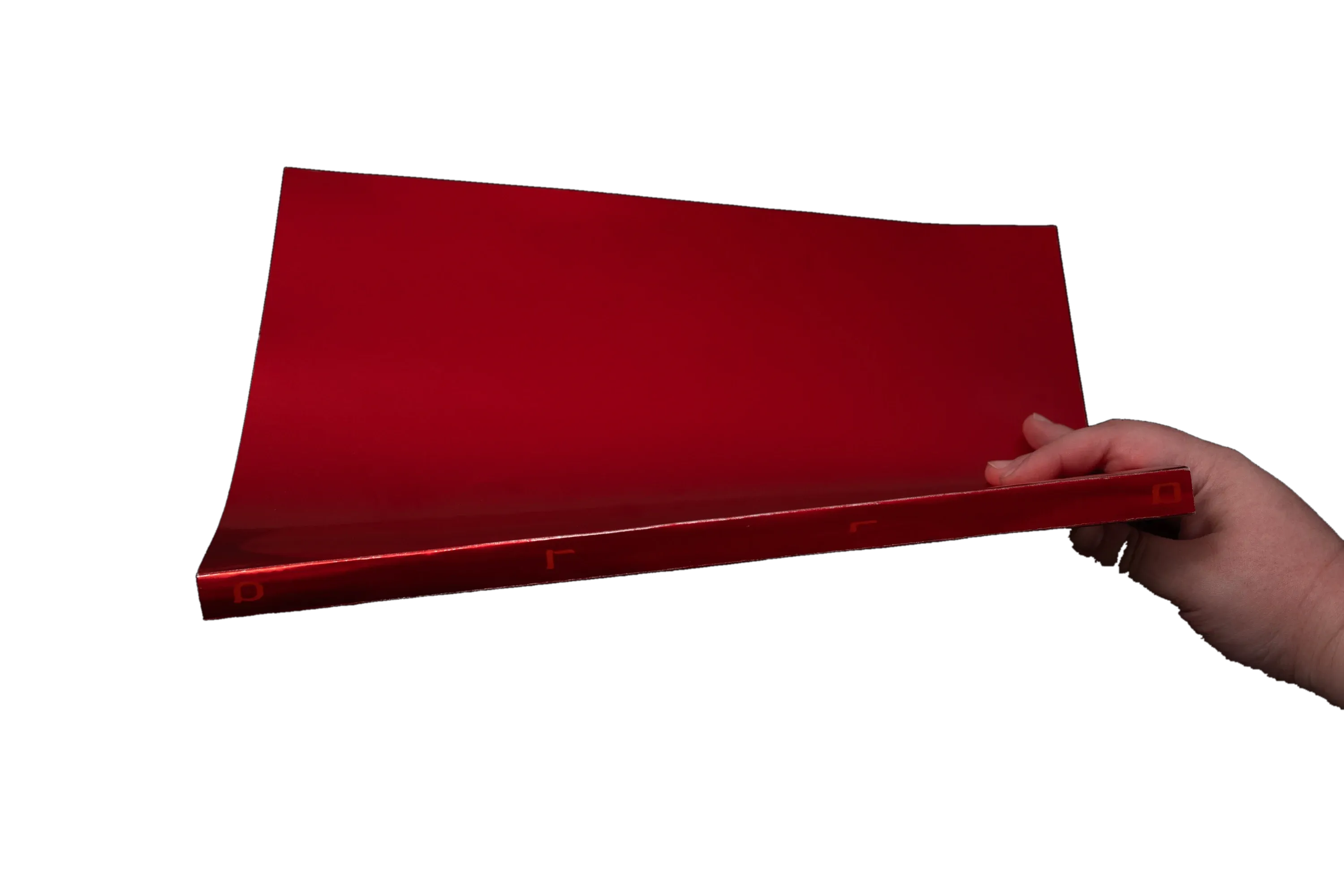A hand opening the red cover of the book Sodom